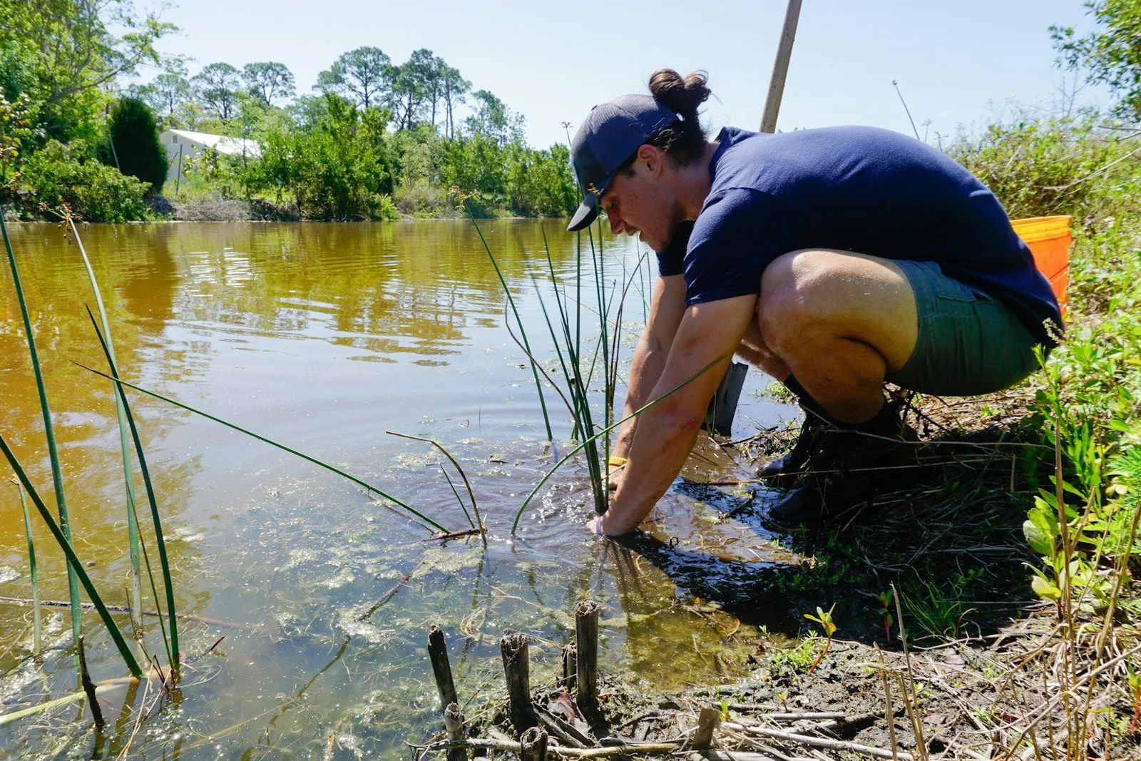 Técnica tomando una muestra de agua en un río de altura